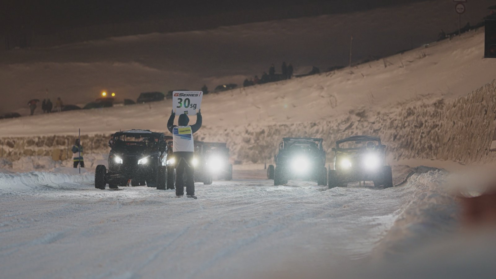 Coches de rally con los focos encendidos sobre la nieve
